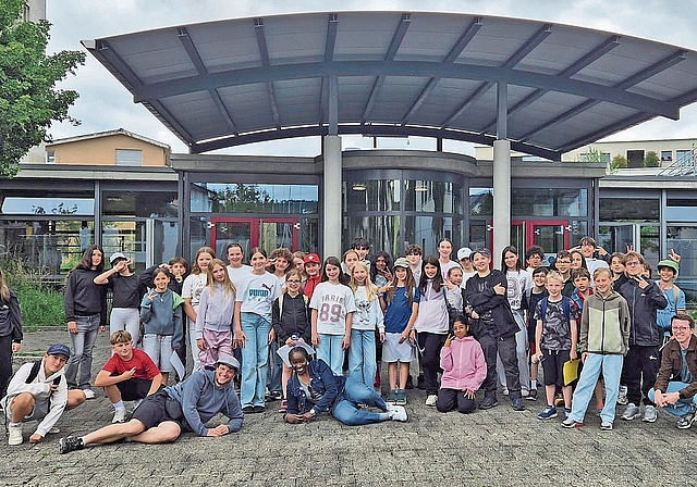 Sprachgrenzen überwinden: Die Klasse aus Lausanne und die Holziker Schülerinnen und Schüler gemeinsam vor dem Schulhaus Dorf.Bild: ZVG