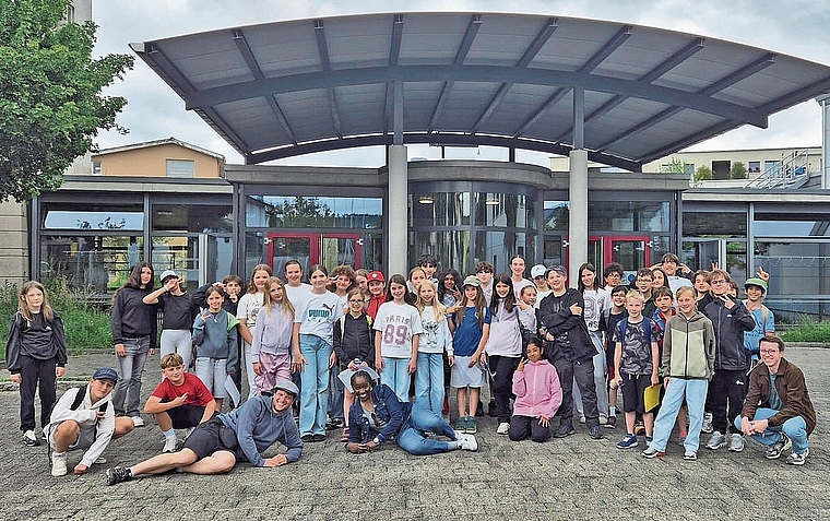 Sprachgrenzen überwinden: Die Klasse aus Lausanne und die Holziker Schülerinnen und Schüler gemeinsam vor dem Schulhaus Dorf.Bild: ZVG