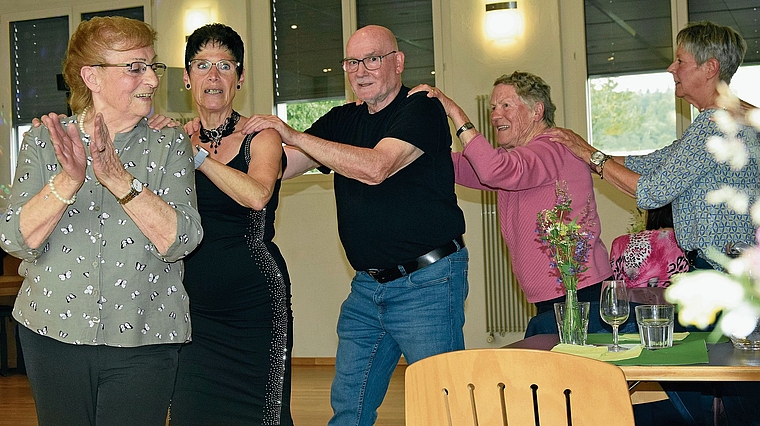 Die Polonaise rund um die blumengeschmückten Tische: Hedy Fischer führte an, hinter ihr die Sängerin Elvira.Bild: Frieda Steffen