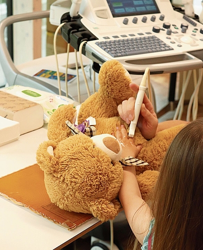 Konzentriert untersucht ein Mädchen sein Bärli per Ultraschall. Konzentriert untersucht ein Mädchen sein Bärli per Ultraschall.