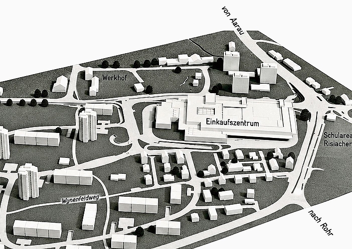 Das Modell (links) zeigt das geplante Einkaufszentrum (mit Hochhäusern) an der Lenzburgerstrasse in Buchs. Weil sich das Baubewilligungsverfahren verzögerte, eröffnete die Migros 1976 im Wynenfeld zunächst ein Provisorium. Daraus entwickelte sich Das Modell (links) zeigt das geplante Einkaufszentrum (mit Hochhäusern) an der Lenzburgerstrasse in Buchs. Weil sich das Baubewilligungsverfahren verzögerte, eröffnete die Migros 1976 im Wynenfeld zunächst ein Provisorium. Daraus entwickelte sich das heutige Wynecenter (rechts), das heuer sein 50-jähriges Bestehen feiert.Bilder: ZVG