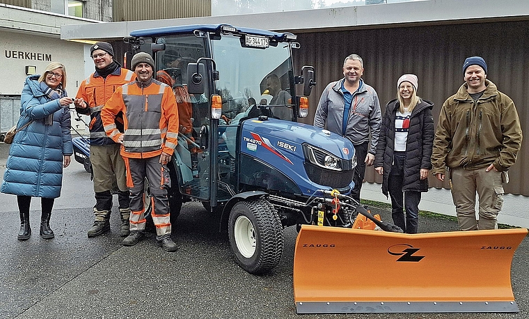 Geschäftsführerin Jeannine Fritschi-Lüscher (Lüscher Landtechnik AG) überreicht Hannes Wilhelm (Leiter Bauamt) den Schlüssel des neuen Fahrzeugs, Marc Bolliger (Bauamt), Gemeinderat Roland Benz, die Stv. Gemeindeschreiberin Larissa Schweizer un