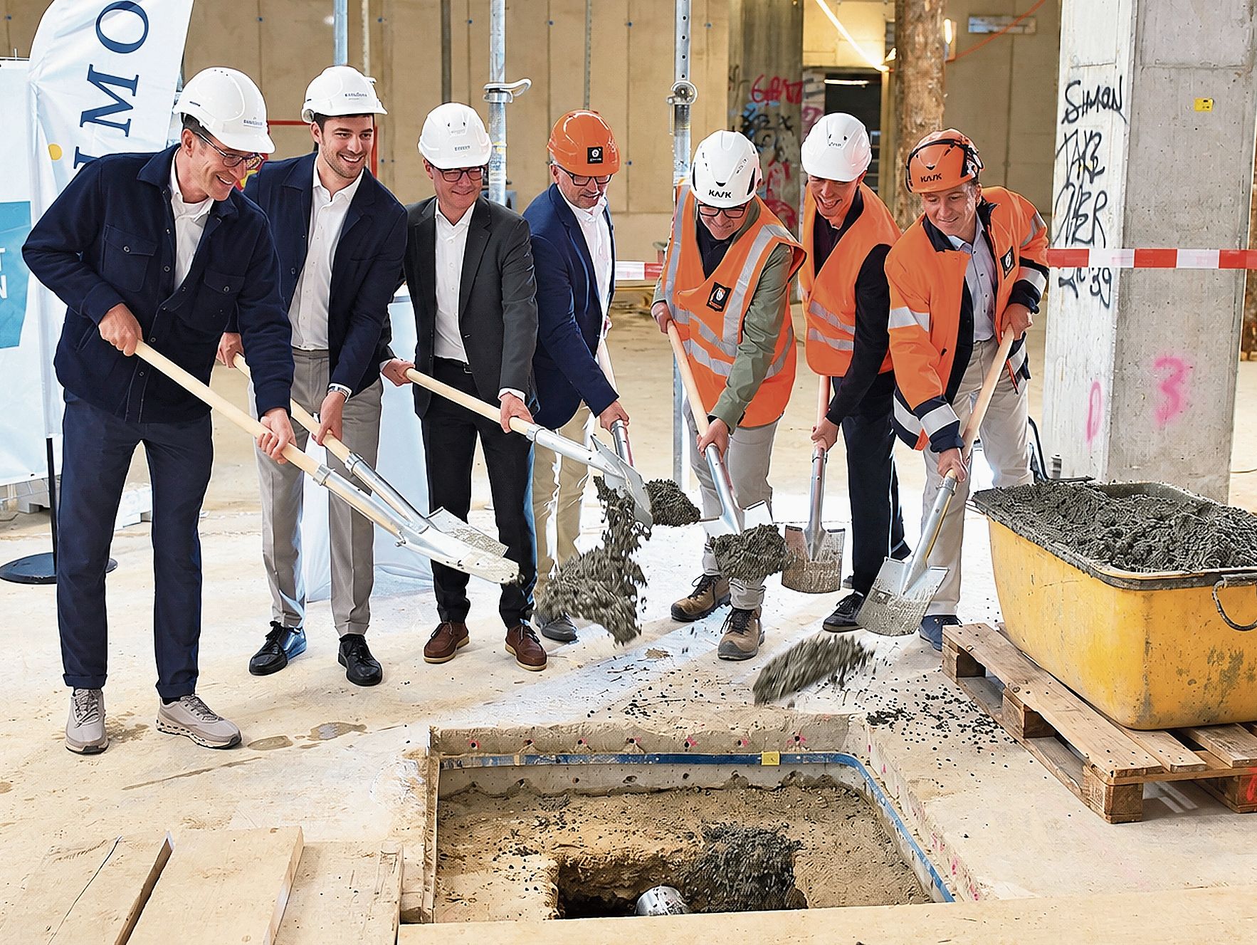Die Zeitkapsel wird einbetoniert: Vertreter der Bauherrin Mobimo AG, Architekt Beat Schneider, Stadtpräsident Hanspeter Hilfiker und Mitarbeitende von Implenia betonieren die Kapsel gemeinsam im Nordbau ein. Bild: RAN